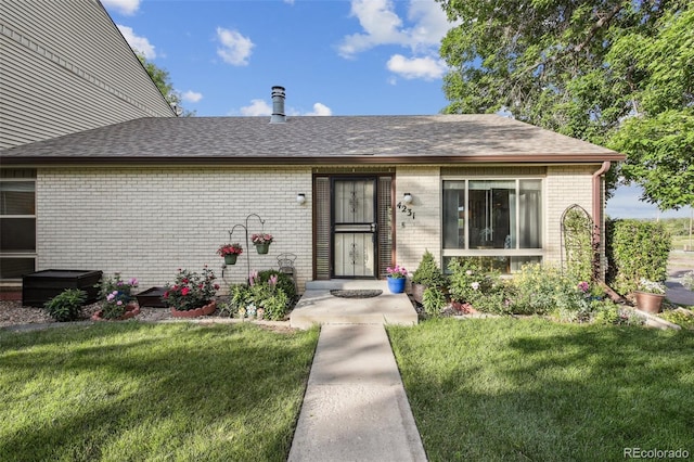 4231 W Ponds Cir, Littleton, CO 80123 - view of front of property featuring brick siding, a front lawn, and roof with shingles