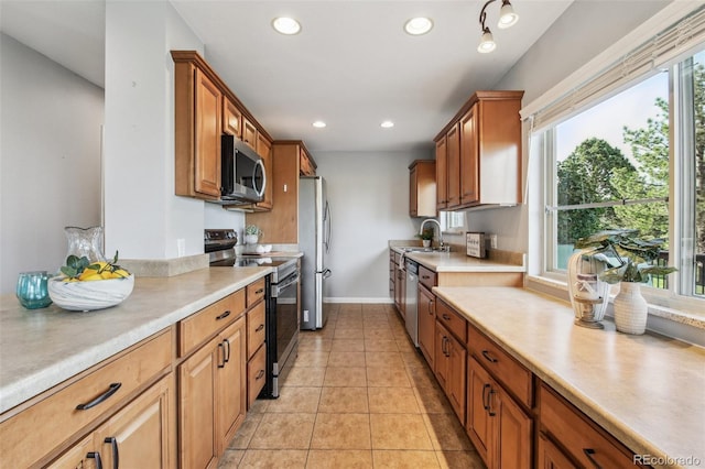 4231 W Ponds Cir, Littleton, CO 80123 - kitchen with stainless steel appliances, light countertops, recessed lighting, light tile patterned floors, and brown cabinets