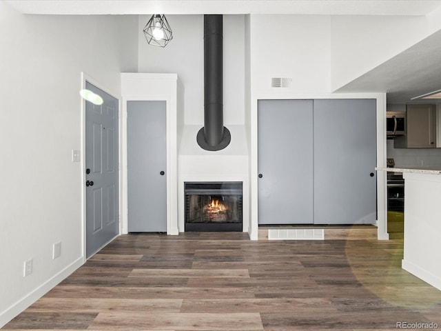 unfurnished living room with a fireplace and dark hardwood / wood-style flooring