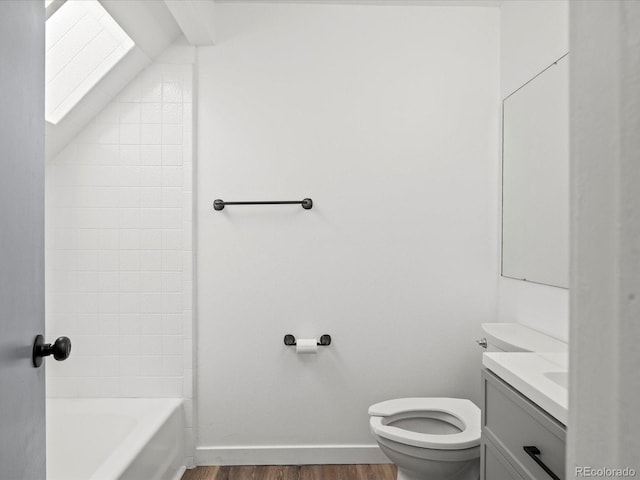 bathroom featuring vaulted ceiling with skylight, vanity, toilet, and wood-type flooring