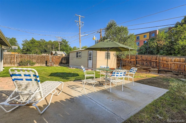 5041 W Nevada Pl, Denver, CO 80219 - fenced backyard with outdoor dining area, a patio, and an outbuilding