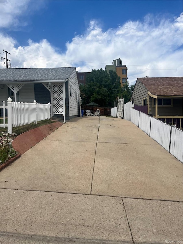5041 W Nevada Pl, Denver, CO 80219 - view of side of home with concrete driveway and a shingled roof