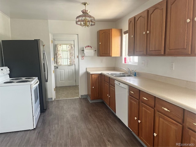 5041 W Nevada Pl, Denver, CO 80219 - kitchen with white appliances, brown cabinetry, dark wood-type flooring, light countertops, and a chandelier