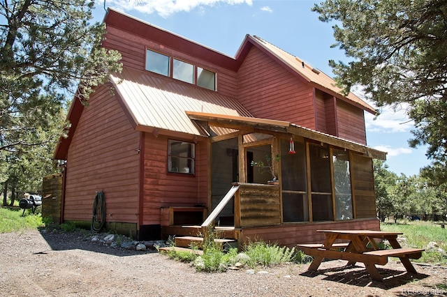 rear view of property featuring a sunroom