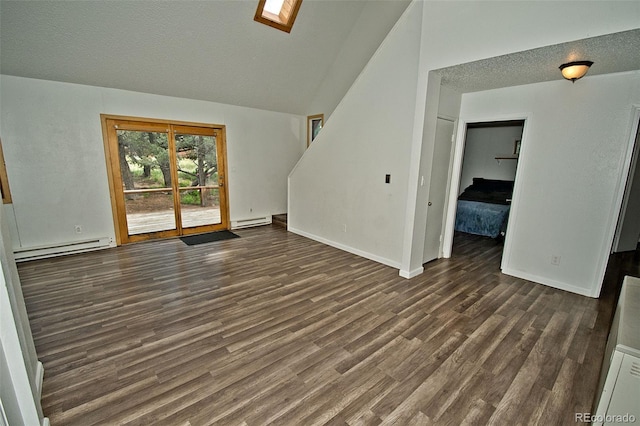 unfurnished living room with dark hardwood / wood-style floors, a skylight, and a baseboard heating unit