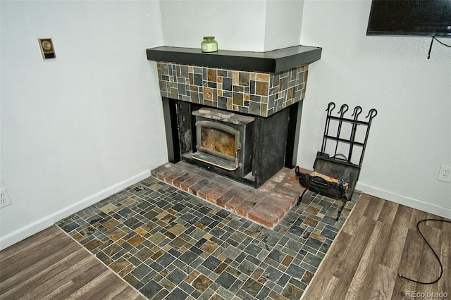 room details with hardwood / wood-style floors and a wood stove