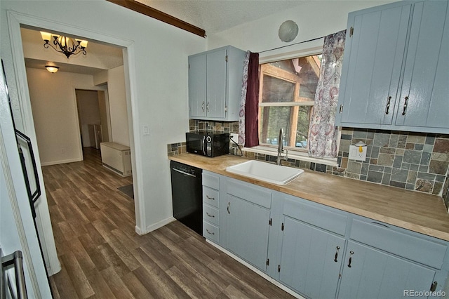 kitchen with tasteful backsplash, sink, black appliances, a chandelier, and dark hardwood / wood-style floors