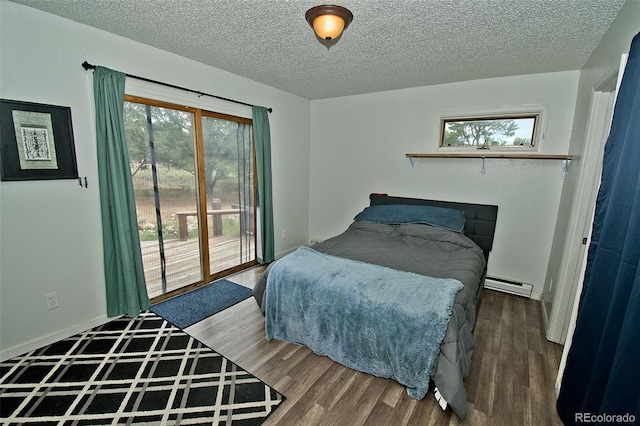 bedroom featuring baseboard heating, dark wood-type flooring, a textured ceiling, and access to outside