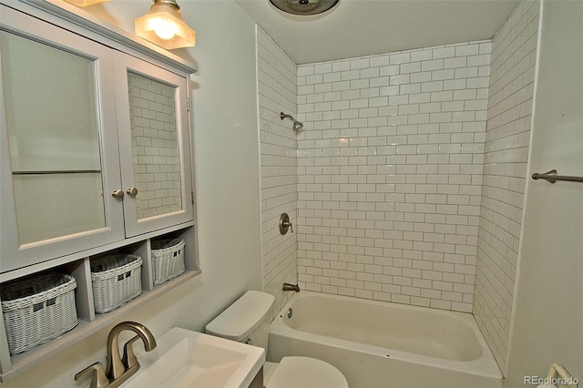 full bathroom with toilet, sink, and tiled shower / bath