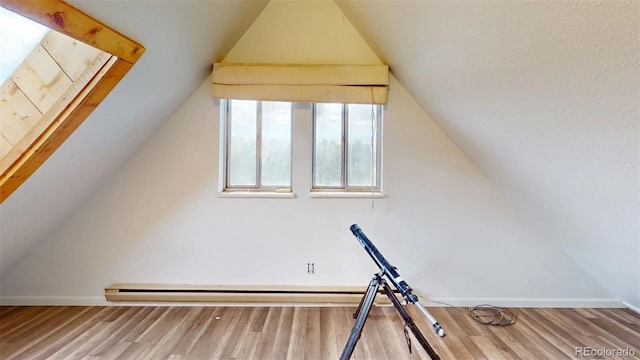 bonus room featuring hardwood / wood-style floors, a baseboard radiator, and vaulted ceiling