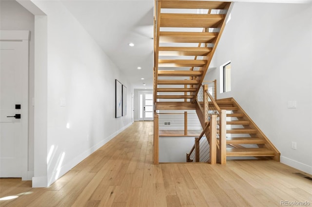 staircase featuring recessed lighting, visible vents, baseboards, and hardwood / wood-style flooring