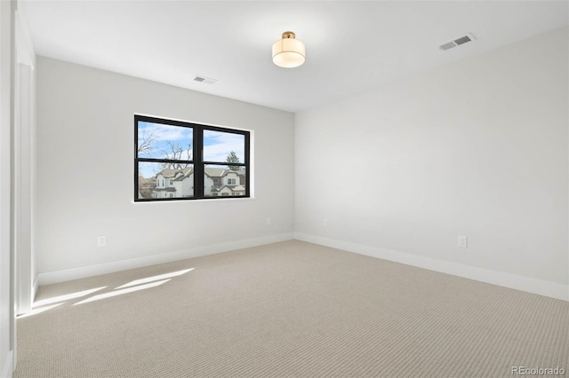 empty room with visible vents, carpet floors, and baseboards