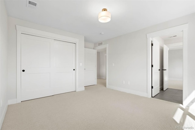 unfurnished bedroom with visible vents, baseboards, carpet, and a closet