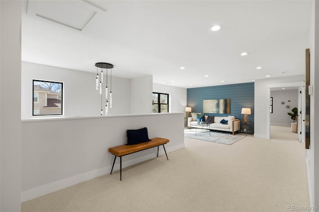 corridor featuring recessed lighting, an accent wall, carpet floors, baseboards, and attic access