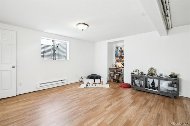 interior space featuring a baseboard heating unit and light hardwood / wood-style floors