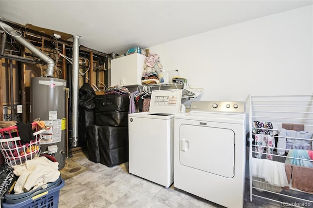 laundry room with cabinets, gas water heater, and washer and dryer