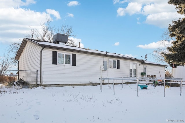 view of snow covered rear of property