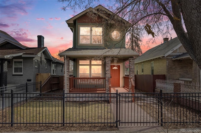 view of front of property featuring a fenced front yard, covered porch, and a gate