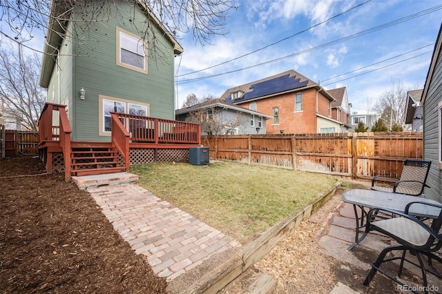 back of property featuring a fenced backyard, a deck, and a yard