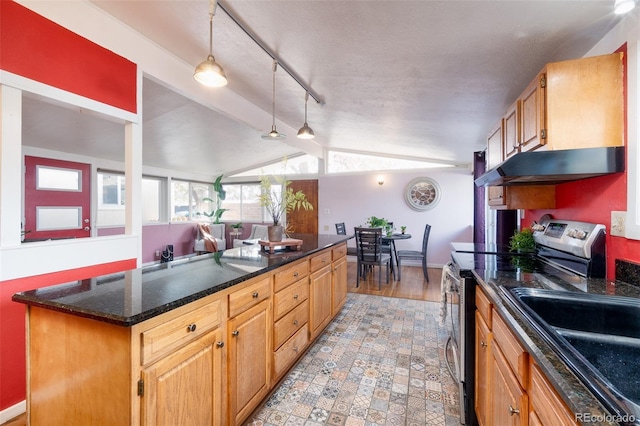 kitchen with lofted ceiling with beams, stainless steel range with electric cooktop, a kitchen island, dark stone countertops, and under cabinet range hood