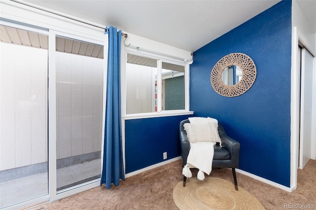 living area featuring carpet flooring and baseboards