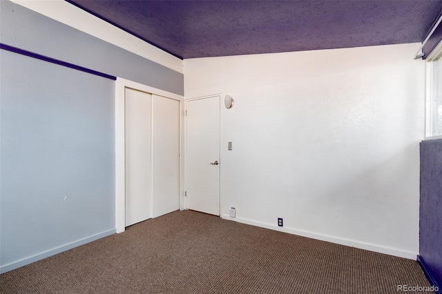 unfurnished bedroom featuring a closet, carpet flooring, and baseboards