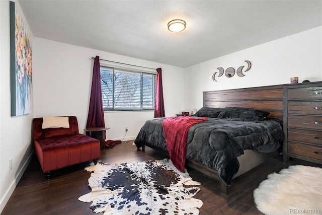 bedroom with baseboards and wood finished floors