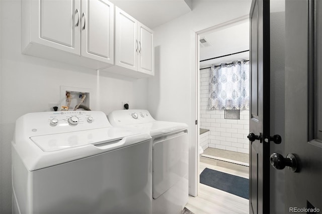 clothes washing area featuring cabinet space, separate washer and dryer, visible vents, and light wood-type flooring