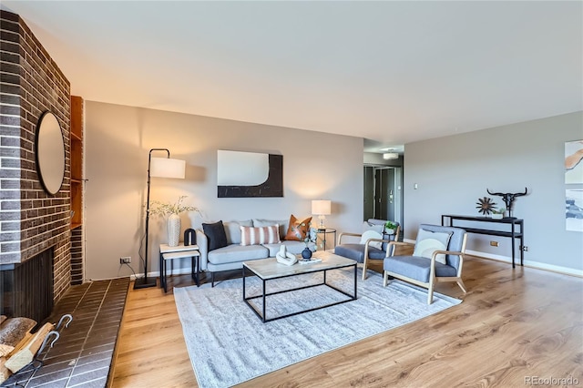 living room with a fireplace, wood finished floors, and baseboards