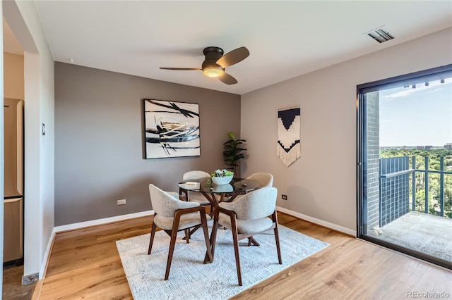 dining space with ceiling fan and light hardwood / wood-style flooring