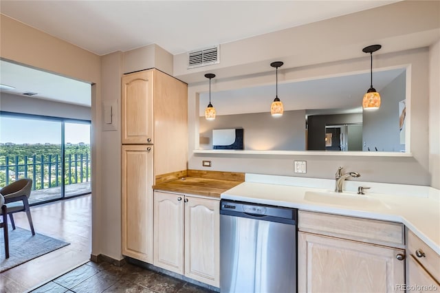 kitchen featuring light brown cabinetry, sink, dishwasher, and pendant lighting