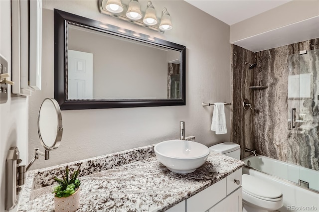 full bathroom featuring shower / bath combination with glass door, vanity, and toilet