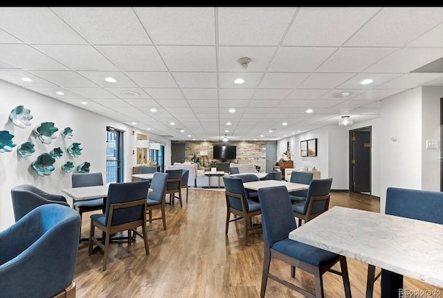 dining area with a paneled ceiling, wood finished floors, and recessed lighting