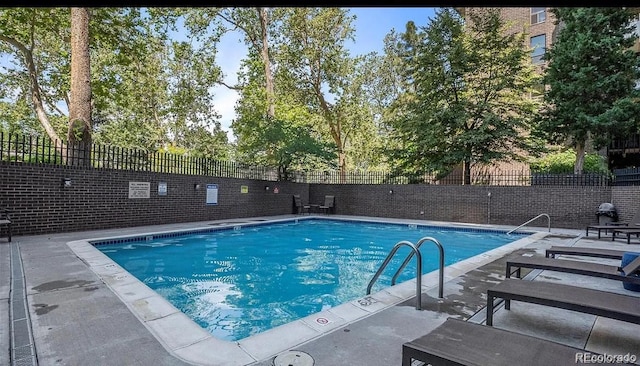 pool with a patio area and fence