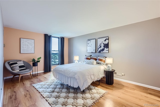 bedroom featuring wood finished floors and baseboards