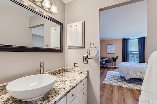 bathroom with connected bathroom, vanity, and wood finished floors