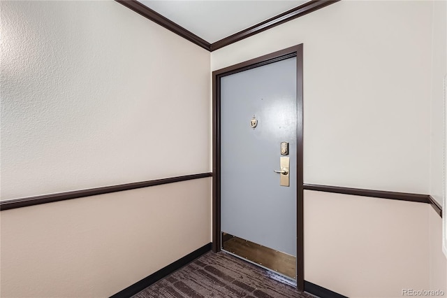 interior space featuring ornamental molding, dark wood-style flooring, and baseboards