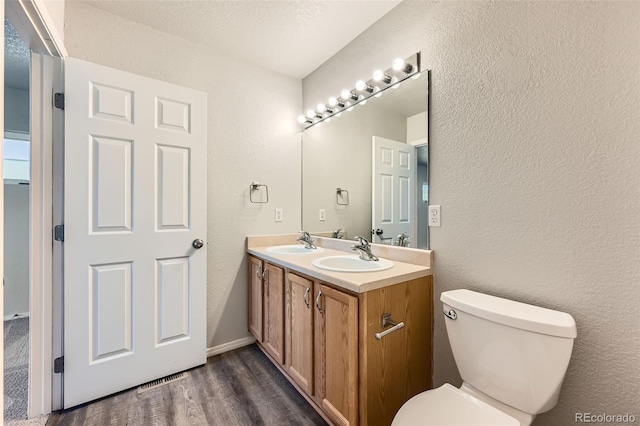 1389 S Quintero Way, Aurora, CO 80017 - bathroom featuring double vanity, wood finished floors, and a textured wall