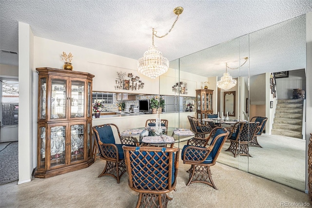 carpeted dining area with an inviting chandelier and a textured ceiling