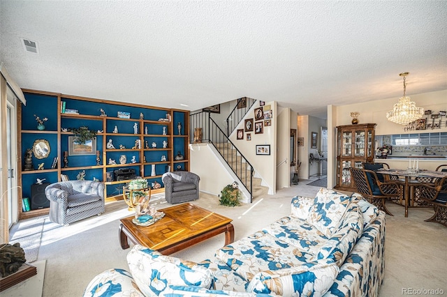 carpeted living room with sink, a chandelier, and a textured ceiling