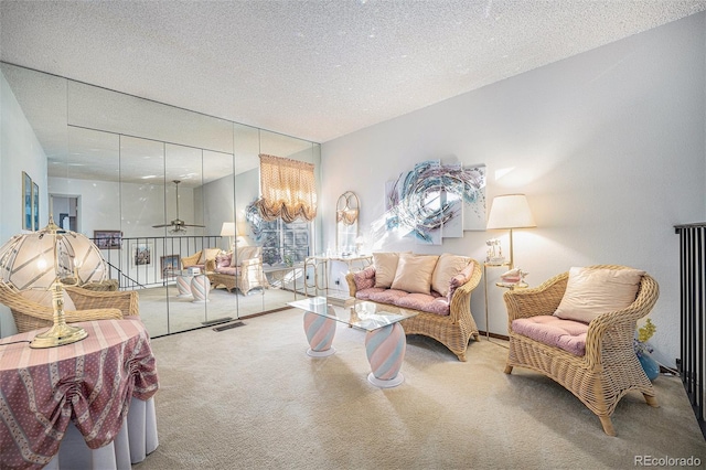 living room featuring carpet floors, a textured ceiling, and ceiling fan