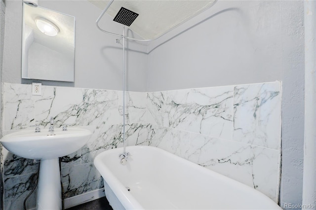 full bath featuring a freestanding bath, a shower, and a sink