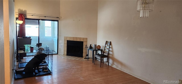 office space with baseboards, a tiled fireplace, and wood finished floors