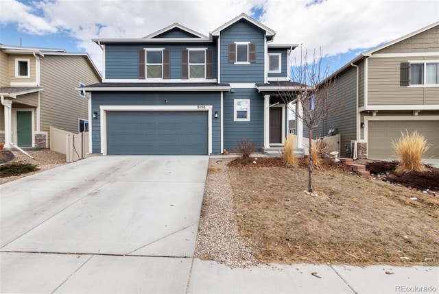 traditional-style home featuring concrete driveway, an attached garage, and fence