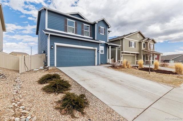 traditional home featuring a garage, driveway, and fence