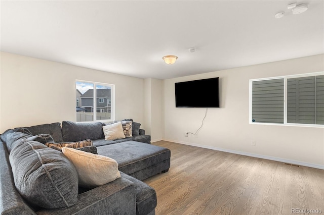 living area with baseboards and wood finished floors