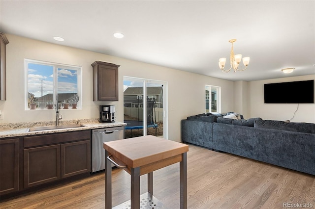 kitchen with a chandelier, dark brown cabinetry, a sink, light wood-type flooring, and dishwasher