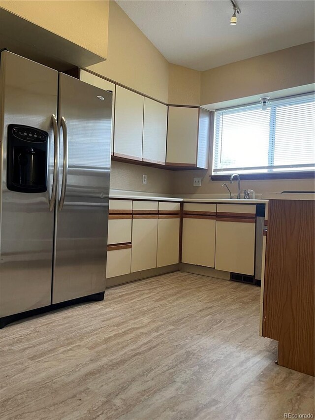 4812 S Bahama Way, Aurora, CO 80015 - kitchen with stainless steel fridge, light wood-type flooring, a sink, light countertops, and white cabinetry