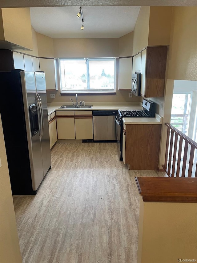 4812 S Bahama Way, Aurora, CO 80015 - kitchen with appliances with stainless steel finishes, a sink, light countertops, light wood-style floors, and rail lighting
