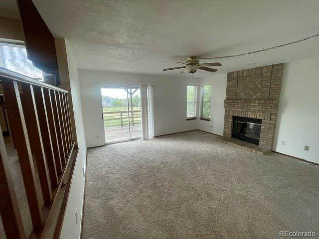 4812 S Bahama Way, Aurora, CO 80015 - unfurnished living room featuring ceiling fan, carpet floors, and a fireplace